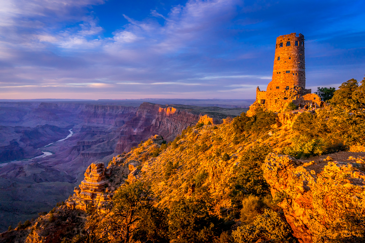 The Desert View Watchtower bathed in an orange glow from the setting sun at Grand Canyon National Park in Arizona
